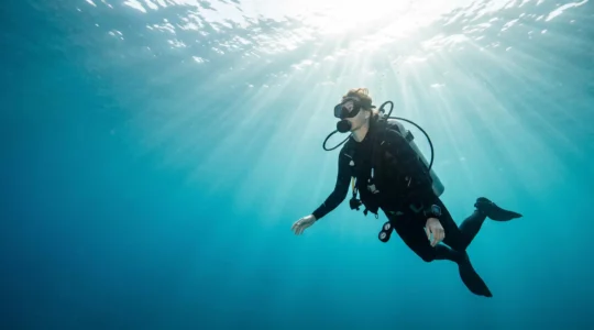 Plongeur en pleine confiance explorant les fonds marins, symbole du parcours de certification réussi